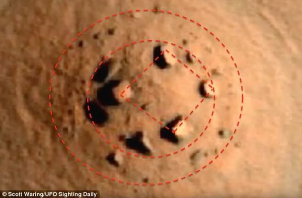 火星轨道勘测器高清晰照相机拍摄到火星地表图，从图中可以明显看出，在隆起的小山丘上，有一个环形石阵。