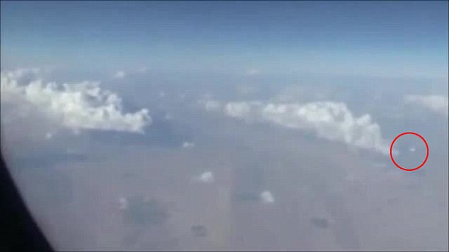 白色、呈圆碟形的UFO(红圈示)在右下方飞过