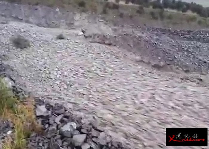 大量灰色的碎石沿着斜坡滚下。