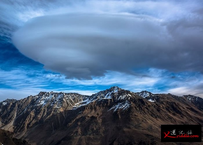 雪山上有一片云，形状似UFO。