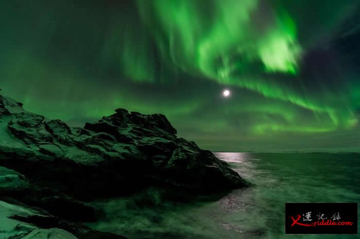在挪威Laksefjorden地区，月色透过夜空中如帘幕般的极光闪耀着。 PHOTOGRAPH BY ERLEND HAARBERG, NATIONAL GEO
