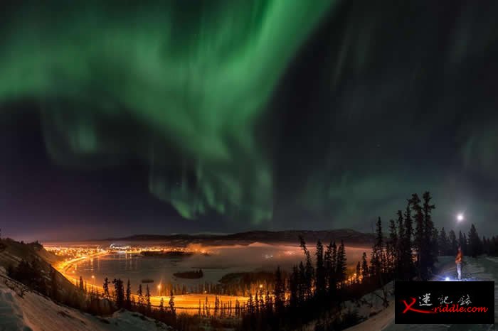 在加拿大育空地区，有名男子正在观看白马市（Whitehorse）上方壮丽的北极光。 PHOTOGRAPH BY PETER MATHER, NATIONAL G